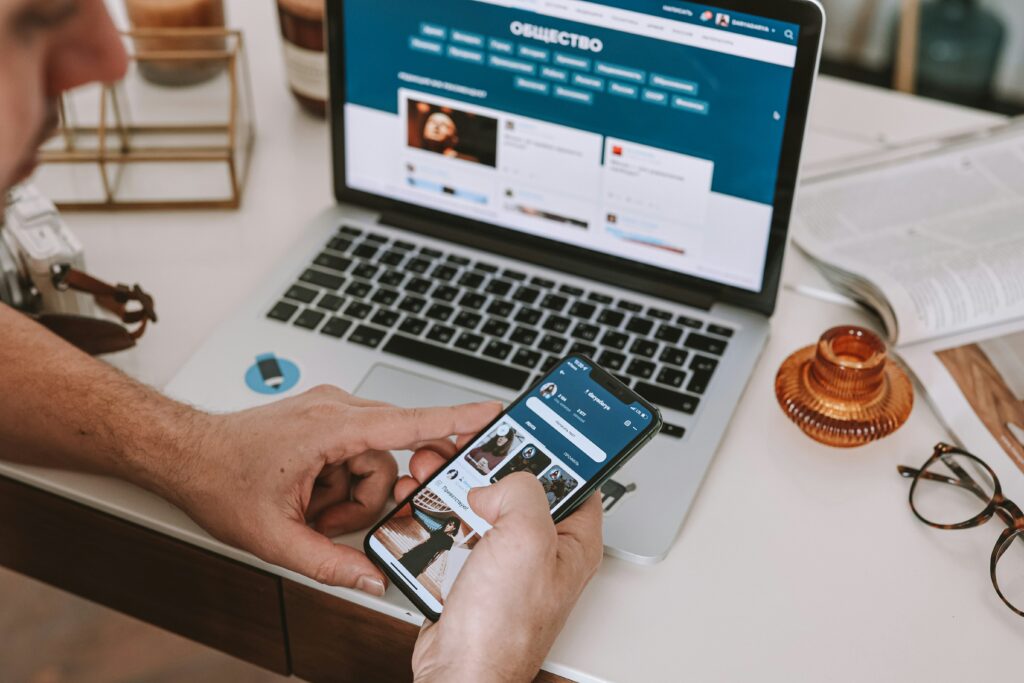 Man sitting down writing a blog on his computer at a desk.