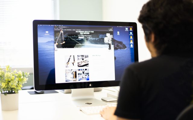 Web designer building a small business website on a desktop computer